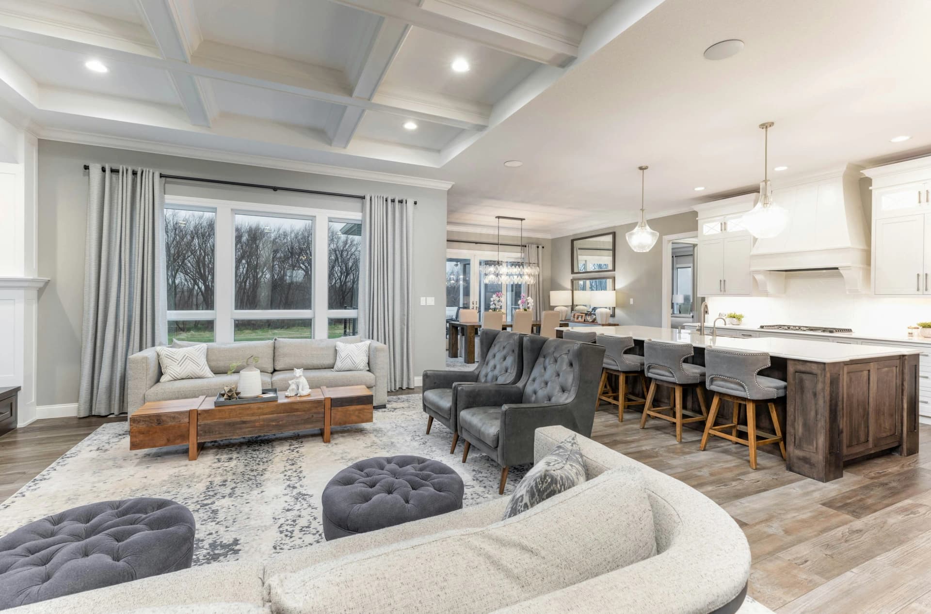 Luxury open-concept living room with coffered ceiling and natural light