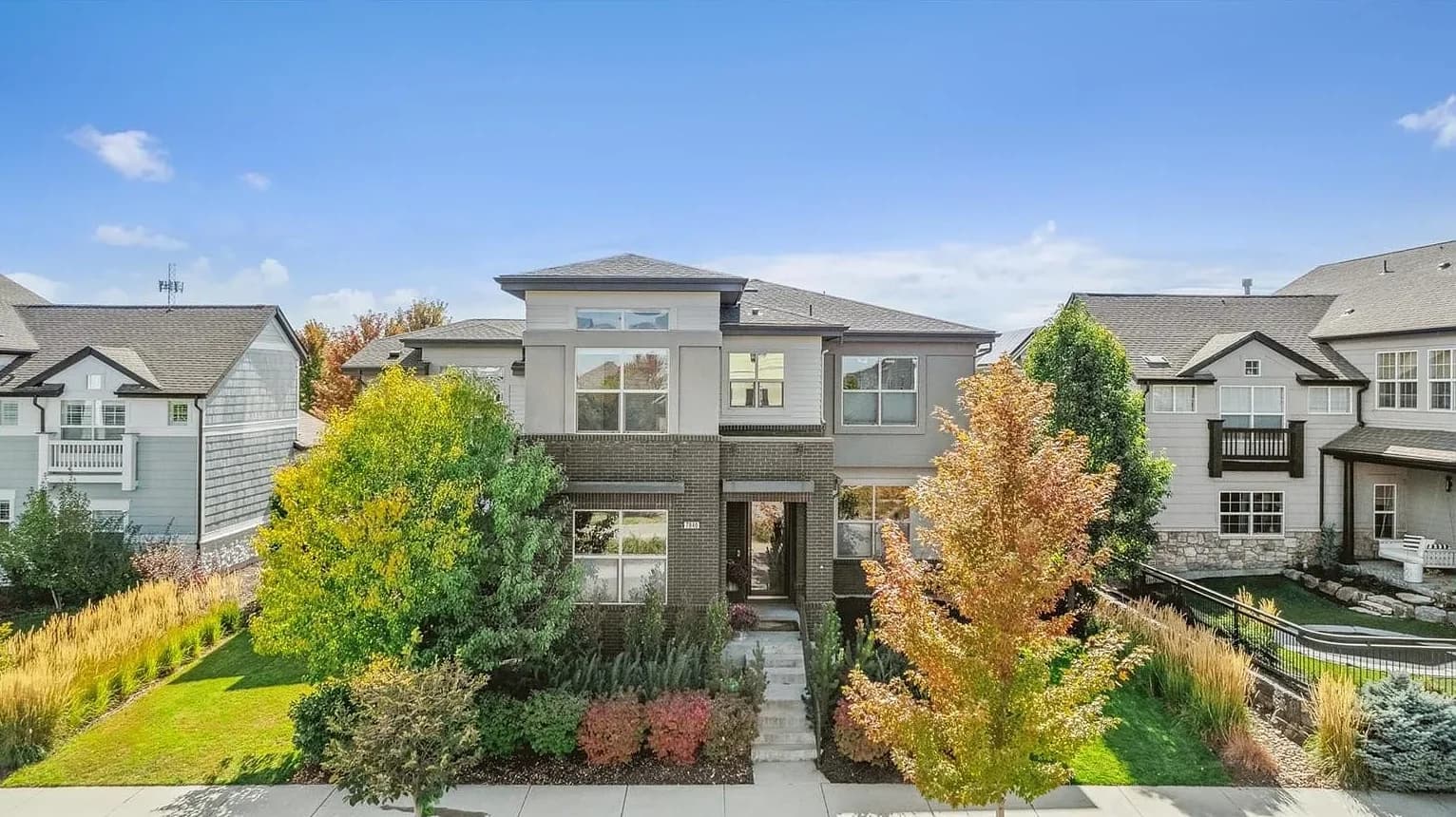 Aerial drone photo of a modern two-story home with fall landscaping in Denver